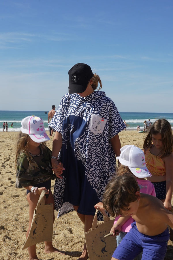 Save La Mermaid poncho on the beach under a blue sky