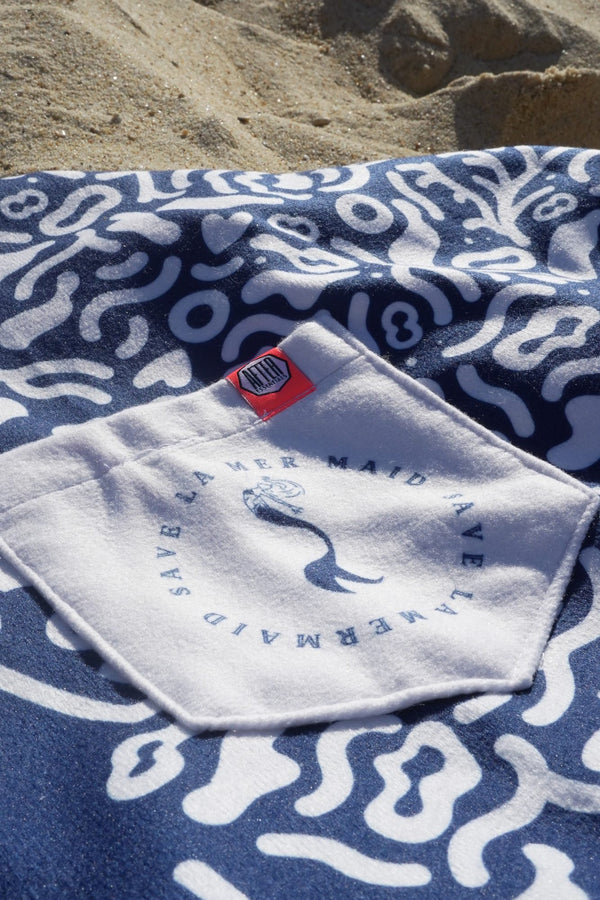 Close-up of the pocket and label on the Save La Mermaid poncho