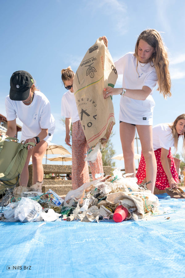 Young volunteers carrying a bag of collected rubbish